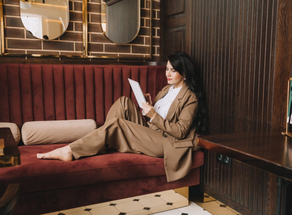 Side profile photo of a business woman talking on the phone. businesswoman sitting on a sofa in a cozy cafe