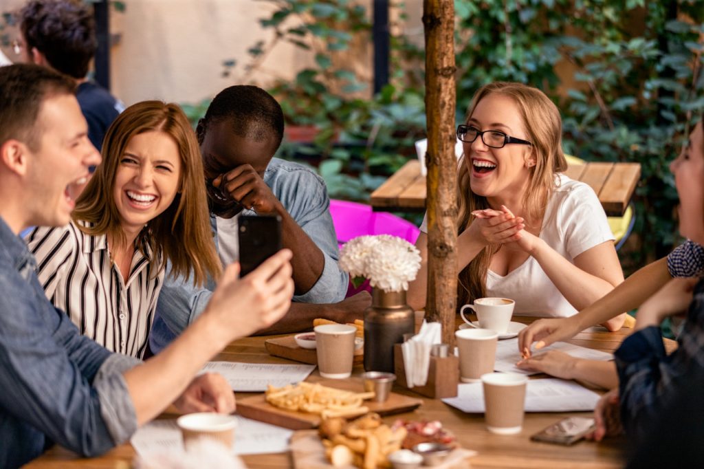 Sincere laugh and showing picture on the smartphone at the casua